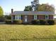 Charming brick home featuring a metal roof, neat landscaping, and a well-maintained front lawn at 1744 Prince Edward Dr, Elon, NC 27244