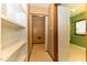 Hallway with built-in shelves leading to the laundry room and a view of the green backyard at 1744 Prince Edward Dr, Elon, NC 27244