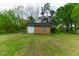 Wooden storage shed with double doors, a window, and a grassy lawn at 1744 Prince Edward Dr, Elon, NC 27244