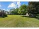 Spacious backyard with mature trees, shed, and partial view of the back of the house at 20 Sanders Rd, Benson, NC 27504