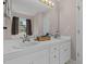 Bathroom with double sinks, white cabinets, a large mirror, and great lighting at 20 Sanders Rd, Benson, NC 27504