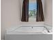 Relaxing soaking tub with window view and elegant chrome fixtures at 20 Sanders Rd, Benson, NC 27504