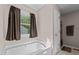 Inviting soaking tub with a window view, and private access to the bathroom at 20 Sanders Rd, Benson, NC 27504
