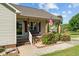 Inviting front porch with red shutters, quaint seating, and lovely landscaping at 20 Sanders Rd, Benson, NC 27504