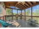 Relaxing screened porch with wood floors, ceiling fan, and ample seating for enjoying the outdoors at 20 Sanders Rd, Benson, NC 27504