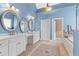 Bathroom with tile floors, blue walls, double sinks, white cabinets, mirrors, and tub at 2000 Silverleaf Dr, Youngsville, NC 27596