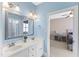 Bright blue bathroom with double vanity and view into bedroom at 2000 Silverleaf Dr, Youngsville, NC 27596