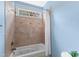 Bright bathroom featuring a tiled tub with a shower and a small window at 2000 Silverleaf Dr, Youngsville, NC 27596