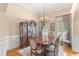 Elegant dining room with a wooden table set for six, accented by a chandelier and natural light at 2000 Silverleaf Dr, Youngsville, NC 27596