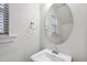 Bright powder room featuring a pedestal sink, oval mirror, window with blinds, and a towel ring at 204 Concordia Woods Dr, Morrisville, NC 27560