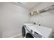 Well-lit laundry room featuring modern front load washer and dryer and shelving for organized storage at 204 Concordia Woods Dr, Morrisville, NC 27560