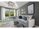 Comfortable living room with gray sofa, table, and abundant natural light streaming through large windows at 211 Faith Ave, Sanford, NC 27330