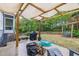 Backyard patio area with a grill, firewood, swing, and green space at 212 Hein Dr, Clayton, NC 27527