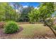 Private backyard with a wooden swing, lush greenery, and a well-maintained lawn at 212 Hein Dr, Clayton, NC 27527