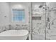 Modern bathroom features a freestanding tub and a glass-enclosed shower with marble tile and fixtures at 212 Hein Dr, Clayton, NC 27527