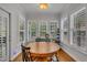 Bright breakfast nook area with a wooden table surrounded by multiple windows and shutter blinds at 212 Hein Dr, Clayton, NC 27527