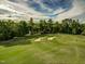 Lush golf course with manicured green, sand bunkers, and tree-lined border under a bright sky at 212 Hein Dr, Clayton, NC 27527