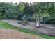 Community playground featuring swings, slides, and climbing structures surrounded by trees and greenery at 212 Hein Dr, Clayton, NC 27527