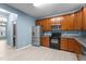 Well-equipped kitchen with stainless steel refrigerator, stove, microwave, wooden cabinets, and granite counters at 2214 Bayswater Dr, Creedmoor, NC 27522