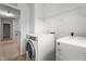 Bright laundry room featuring a washer and dryer, complemented by storage shelves at 2214 Bayswater Dr, Creedmoor, NC 27522