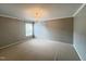 A cozy carpeted bedroom with a chandelier and neutral walls with bright natural lighting at 222 Creststone Dr, Cary, NC 27519
