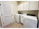 A functional laundry room includes cabinetry, washer, dryer, and a louvered door at 222 Creststone Dr, Cary, NC 27519