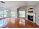 Bright living room with fireplace, hardwood floors, and large windows overlooking the backyard at 222 Creststone Dr, Cary, NC 27519