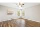 Minimalist bedroom with wood floors, a ceiling fan, and two sunny windows at 225 Lodestone Dr, Durham, NC 27703