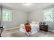 Cozy bedroom with two windows, light gray walls, and wood-look flooring at 2314 Clements Dr, Durham, NC 27704