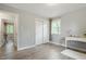 Bright bedroom with gray walls, laminate flooring, closet, window, and white desk at 2314 Clements Dr, Durham, NC 27704