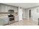 Updated kitchen featuring stainless steel appliances, modern countertops, gray cabinets, and a stylish backsplash at 2314 Clements Dr, Durham, NC 27704
