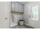 Neutral laundry room with overhead storage and access to exterior at 2314 Clements Dr, Durham, NC 27704