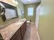 Bathroom featuring an extended countertop, framed mirror, and tiled flooring at 2385 Olde Spring Ct, Graham, NC 27253