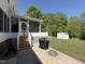 Exterior view of a screened-in patio with stairs leading down to a backyard with a grill at 2385 Olde Spring Ct, Graham, NC 27253