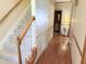 Hallway and stairs featuring hardwood floors and carpeted steps at 2385 Olde Spring Ct, Graham, NC 27253