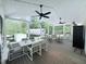 A screened-in patio features a dining area, ceiling fans, and an outdoor living space at 2385 Olde Spring Ct, Graham, NC 27253