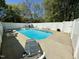 Inviting backyard pool area with a white privacy fence, ample seating, and clear blue water at 2385 Olde Spring Ct, Graham, NC 27253