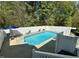 Inviting backyard swimming pool with a white fence, lounge chairs, and a view of the surrounding trees at 2385 Olde Spring Ct, Graham, NC 27253