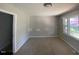 A carpeted bedroom with a window offering an outside view, painted light gray walls and simple ceiling light at 24 Pine St, Franklinton, NC 27525