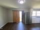 Room with wood flooring, a stainless steel refrigerator and a kitchen area with white cabinets at 24 Pine St, Franklinton, NC 27525