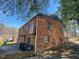 View of the side and back of a brick house showing several windows, gutters and the roof at 24 Pine St, Franklinton, NC 27525