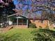 Charming brick home with covered porch, lush lawn and attractive flowering trees in a residential neighborhood at 24 Pine St, Franklinton, NC 27525
