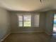 Living room featuring carpeted floors, neutral walls, a ceiling light, with a view of the front yard at 24 Pine St, Franklinton, NC 27525