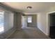 Bright living room featuring carpeted floors, a ceiling light, and freshly painted walls with a view of the neighborhood at 24 Pine St, Franklinton, NC 27525