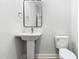 Clean, simple bathroom featuring a pedestal sink and toilet at 241 Indigo St, Lillington, NC 27546