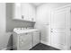 Clean, well-lit laundry room featuring modern washer and dryer, plus white cabinets for storage at 241 Indigo St, Lillington, NC 27546