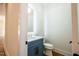 Stylish powder room with a blue vanity, marble countertop, and illuminated mirror at 3000 Eden Harbor Ct, Raleigh, NC 27613