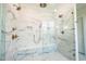 Walk-in shower with marble surround, multiple shower heads, a built in seat, and a glass door at 3000 Eden Harbor Ct, Raleigh, NC 27613