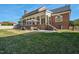 Spacious backyard with a covered porch featuring outdoor seating, a green lawn and a red brick home at 3001 Greystone Dr, Rocky Mount, NC 27804