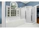Bright bathroom featuring a large garden tub with window and a glass enclosed shower at 3001 Greystone Dr, Rocky Mount, NC 27804